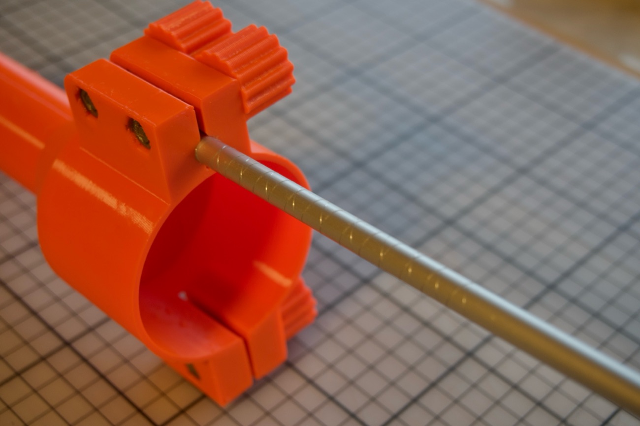 Detailaufnahme des orange 3D-gedruckten Adapters am Vermessungsstab